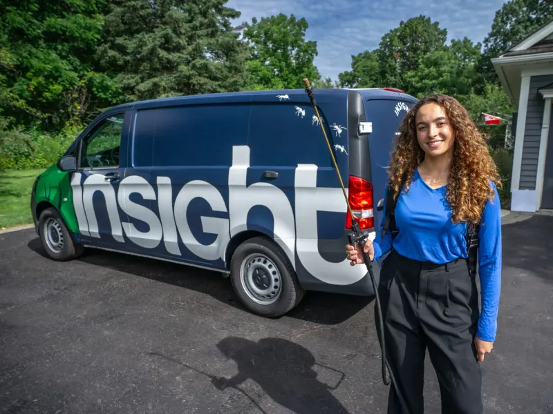 Technicienne d'Insight Pest Solutions devant un camion de service